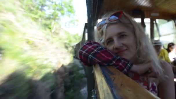 Blonďatá žena se dívá oknem, když cestuje vlakem, těsně předtím, než vlak vjíždí do tunelu