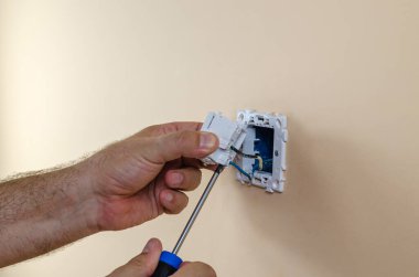 Adamın elleri modüler düğmeye elektrik kabloları bağlıyor.