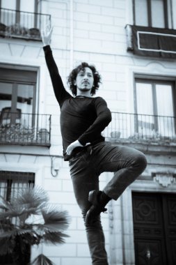 Erkek dansçı performans gösteren tek ayak üzerinde dönüş. Kentsel arka plan