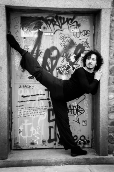 Erkek dansçı bir klasik bale tek ayak üzerinde dönüş yapıyor. Kentsel arka plan