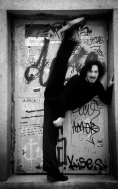 Erkek dansçı bir klasik bale tek ayak üzerinde dönüş yapıyor. Kentsel arka plan