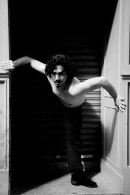 Latin erkek dansçı dans figürleri ile poz. Kentsel arka plan