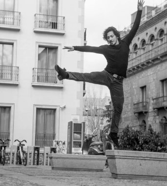 Erkek dansçı performans gösteren tek ayak üzerinde dönüş. Kentsel arka plan