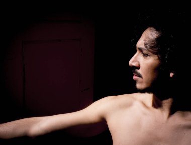 Latin erkek dansçı dans figürleri ile poz. Kentsel arka plan