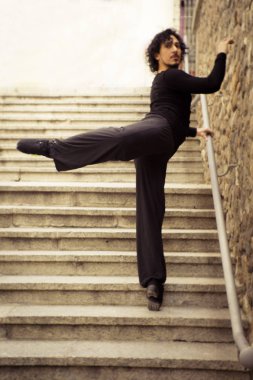 Erkek dansçı bir klasik bale tek ayak üzerinde dönüş yapıyor. Kentsel arka plan