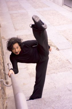 Erkek dansçı bir klasik bale tek ayak üzerinde dönüş yapıyor. Kentsel arka plan