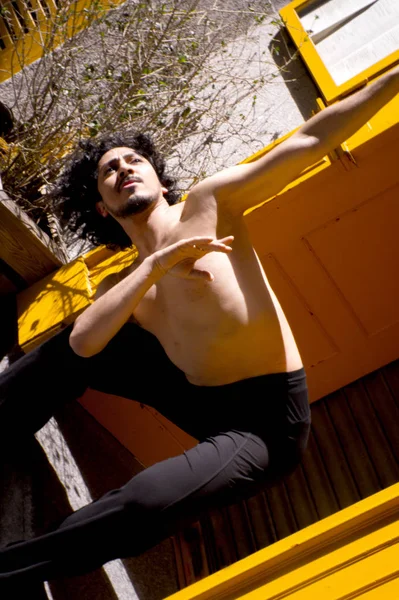 Latin erkek dansçı dans figürleri ile poz. Kentsel arka plan