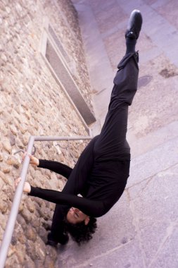 Erkek dansçı bir klasik bale tek ayak üzerinde dönüş yapıyor. Kentsel arka plan