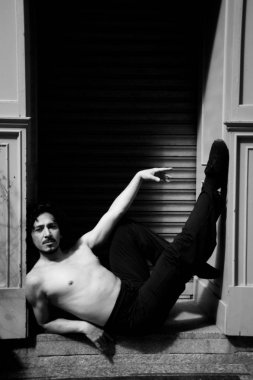 Latin erkek dansçı dans figürleri ile poz. Kentsel arka plan