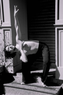 Latin erkek dansçı dans figürleri ile poz. Kentsel arka plan