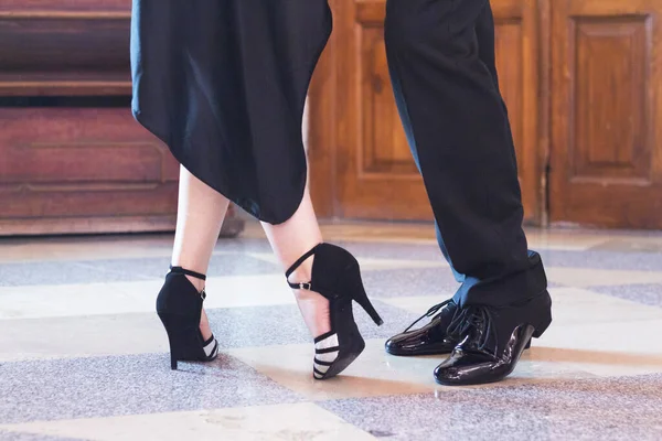 Legs of man and woman dancing Argentine tango. Black shoes