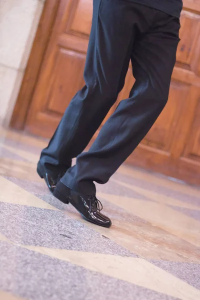 Legs of dancer man in motion. Black dress