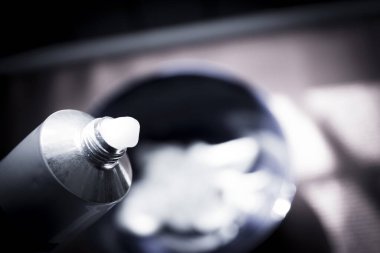 Saç boyamak için karıştırılmış mavi kase. Tüpten saç boyası çıkıyor.