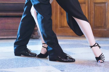 Legs of man and woman dancing Argentine tango. Black shoes clipart