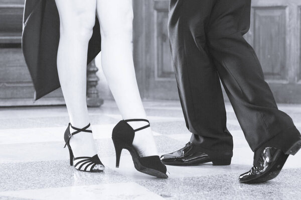 Legs of man and woman dancing Argentine tango. Black shoes