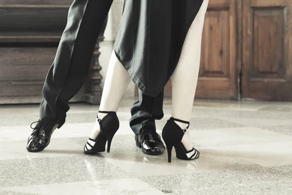 Legs of man and woman dancing Argentine tango. Black shoes