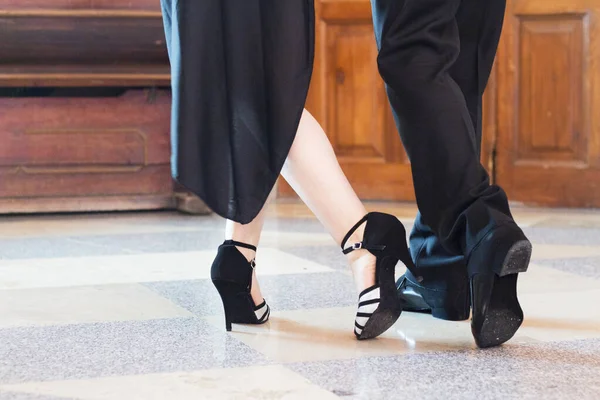 Legs of man and woman dancing Argentine tango. Black shoes