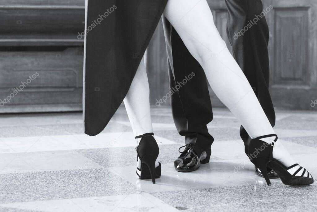 Legs of man and woman dancing Argentine tango. Black shoes
