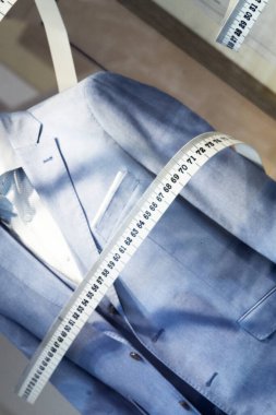Dikiş sayacıyla çevrili bir erkek kıyafeti. Kimse yok.