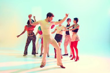 Eski moda kıyafetler ve parlak ışıklarla grup kutlamalarında dans eden arkadaşlar. Gençlik kültürü kavramı, partiler, müzik etkinlikleri ve neşeli eğlence.