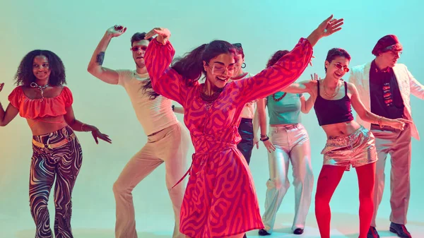 Eski moda partilerde arkadaşlarının önünde dans eden neşeli bir kadın. Mutluluk kavramı, gece hayatı kültürü, eğlence yaşam tarzı ve yaratıcı hareket.