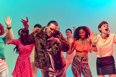 Leopar kürklü bir adam grubun önünde neşeli bir enerjiyle dans ediyor. Bireysellik kavramı, kültürel gece hayatı, klasik moda, müzik kimliği ve performans tutumu.