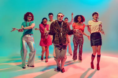 Renkli stüdyoda dans eden kendine güvenen kürklü adam. Liderlik kavramı, karizma, gece hayatı modası, kültürel birlik ve müzik güdümlü eğlence.