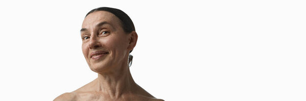 Пожилая женщина тихо улыбается, показывая естественную кожу и морщины. Концепция реальных кампаний тела, скинкаре, социальных проектов, принятия красоты и культурной самобытности. Баннер