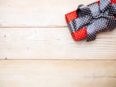 Kırmızı hediye kutusu ahşap tahta üzerinde. Uzay kopyalayın. Tatil kavramı
