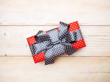 Hediyelik kutu ahşap tahta üzerinde yay ile ışıltılı gazetede. Tatil kavramı