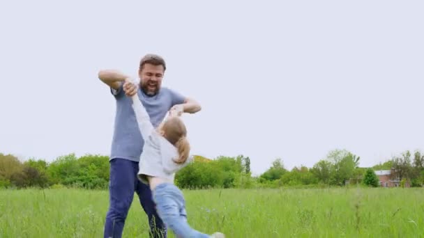 Papa spielt mit Tochter auf dem Feld, wirft und kreist. Spaß mit der Familie im Freien. — Stockvideo
