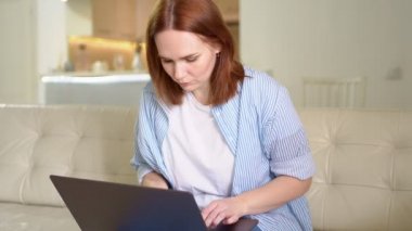 Dizüstü bilgisayar kullanan, yazı yazan, koltukta oturan bir kadın..