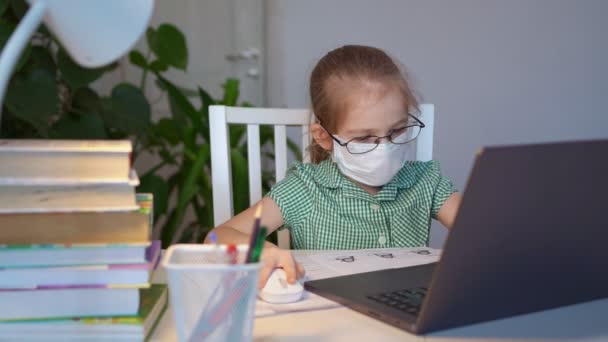 Kid girl in glasses and mask learn on laptop. distance education. — Stock Video