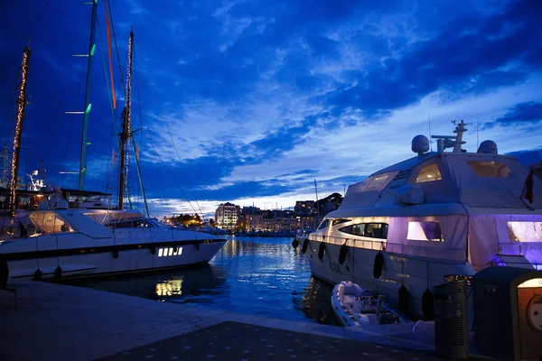 Luxurious yachts and boats in the port at night. evening, pier, sea, and sky. — Stock Photo, Image