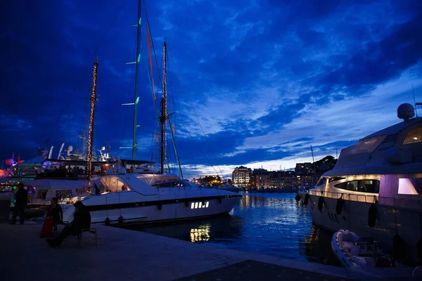 Luxurious yachts and boats in the port at night. evening, pier, sea, and sky. — Stock Photo, Image