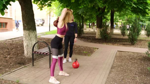 Girl athlete doing squats with weight on group fitness classes outdoors. — Stock Video