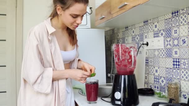 Gezond voedsel. het meisje bereidt smoothie in uw keuken. — Stockvideo