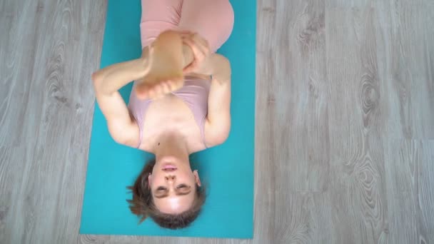 Atleta menina envolvida em esportes em casa, fazendo alongamento no tapete de ioga . — Vídeo de Stock