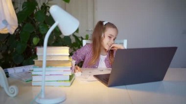 Kulaklıklı genç kız online dersin sonunda seviniyor.