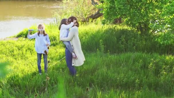 Alegre familia feliz tener un picnic y jugar inflar burbujas de jabón . — Vídeos de Stock