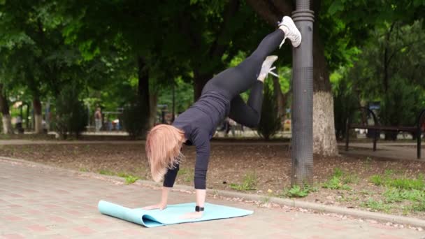 Fille athlète en vêtements de sport dans le parc en plein air utilisé pole. entraînement en plein air . — Video