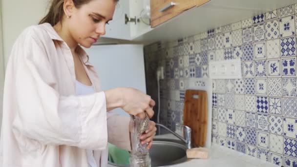 Mädchen gießt Chia-Samen in ein Glas. — Stockvideo