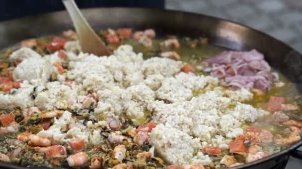 Açık havada büyük tavada pişmiş deniz mahsullü risotto. Sokak yemeği. Festival. — Stok video