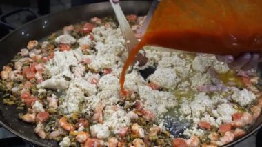 Açık havada pişirilmiş risotto, büyük tavada domates ezmesi. Sokak yemeği. Festival.