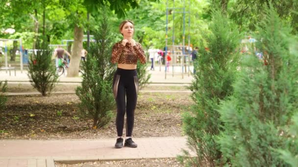 Fille athlète en vêtements de sport, faire des squats, étirement dans le parc . — Video