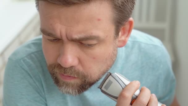 Hombre hace el corte de la barba con una navaja de afeitar en casa . — Vídeos de Stock