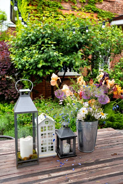 Table in garden of country house. candlesticks and bouquet of flowers. — Stock Photo, Image