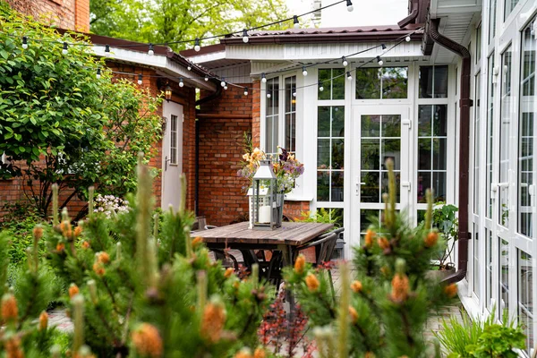 乡村住宅花园的餐桌。烛台和花束. 图库图片