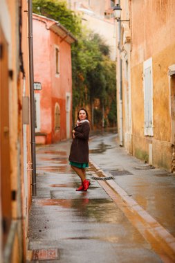 Kız Provence France 'ın küçük bir kasabasında yağmur altında yürüyor. Avrupa seyahati.