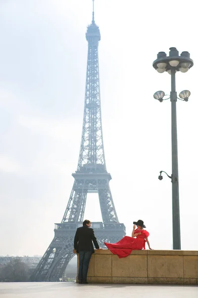 Man and woman in red dress and hat on Eiffel tower in Paris. symbol of France. — Stock Photo, Image